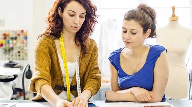 Fit engineer teaching student with fabric swatches