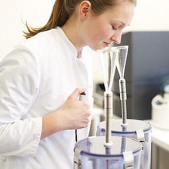 Malodour tests for detergents Professionelle Snifferin beim Beurteilen zweier Geruchsproben
